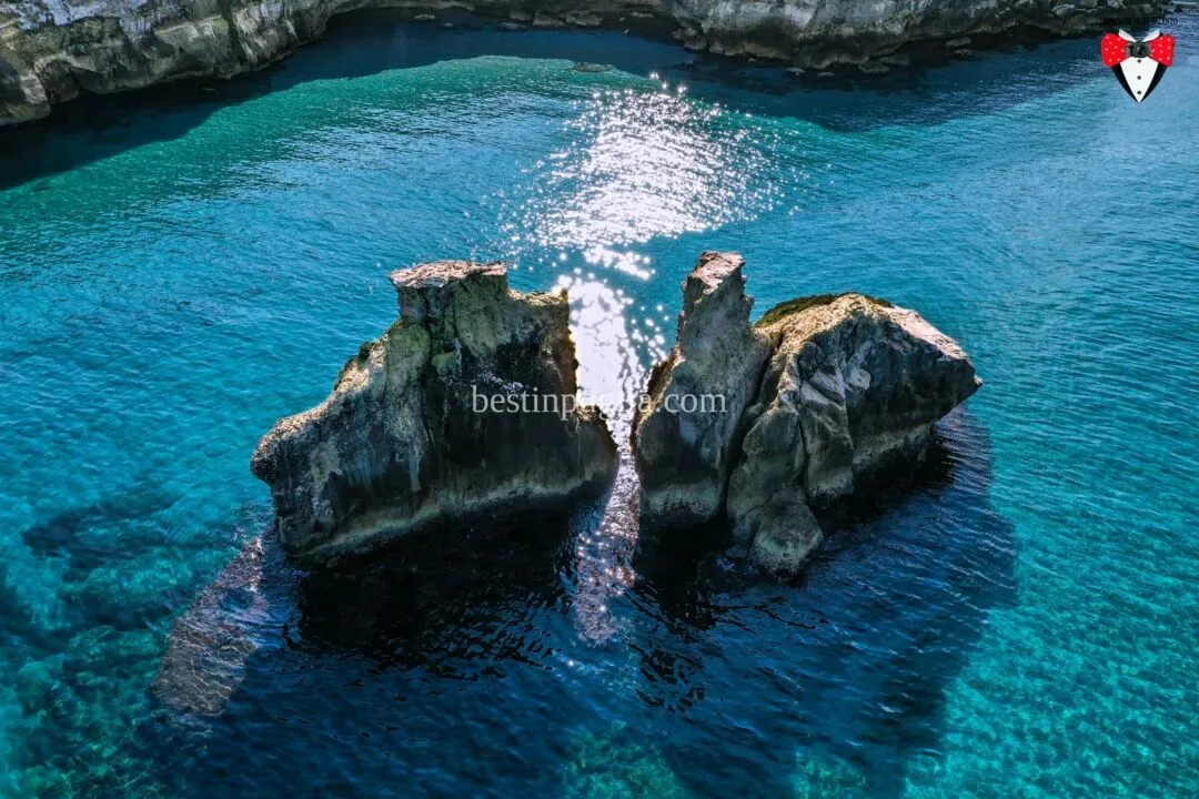 Les Deux S&oelig;urs : les piles qui sortent de l'eau devant la plage de Torre dell'Orso