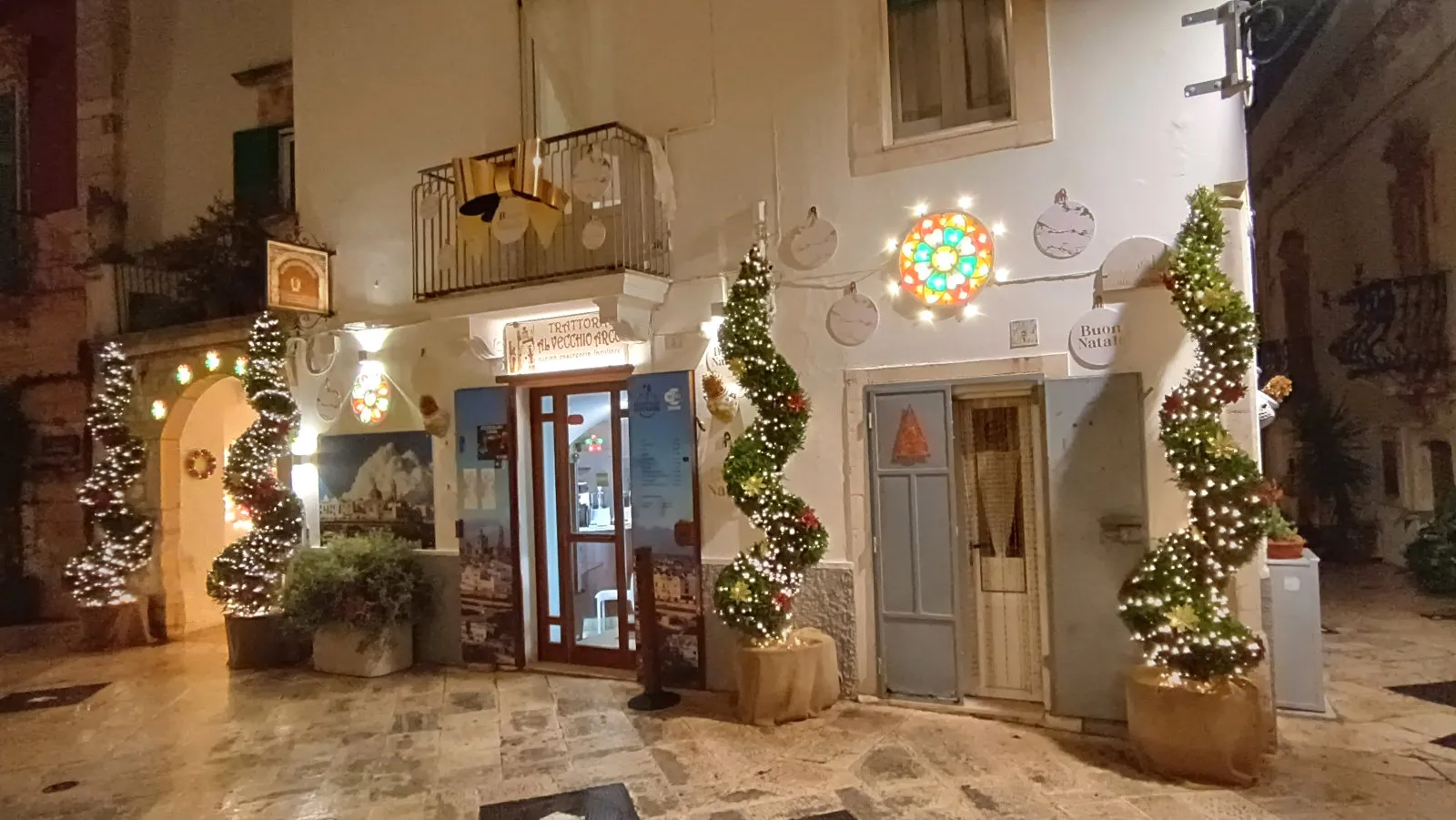 Locorotondo natale, ingresso trattoria illuminato da luminarie natalizie in centro storico a locorotondo