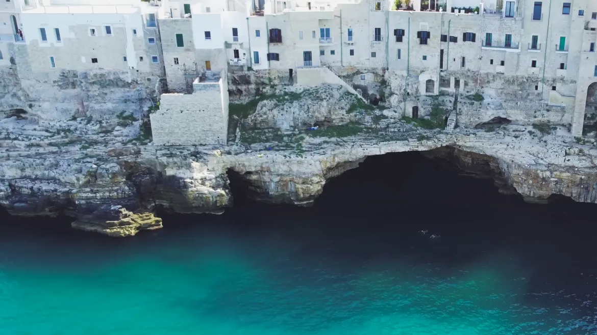 Polignano a Mare, vista di grotte e caverne marine ai piedi della scogliera sotto al centro storico