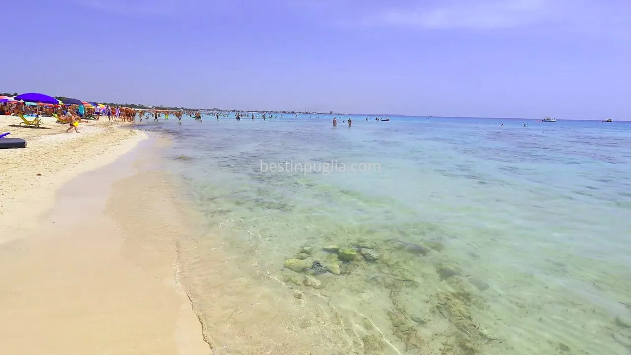 Strand von Torre Lapillo: Blick auf den Strand mit Badeg&auml;sten und transparentem Wasser